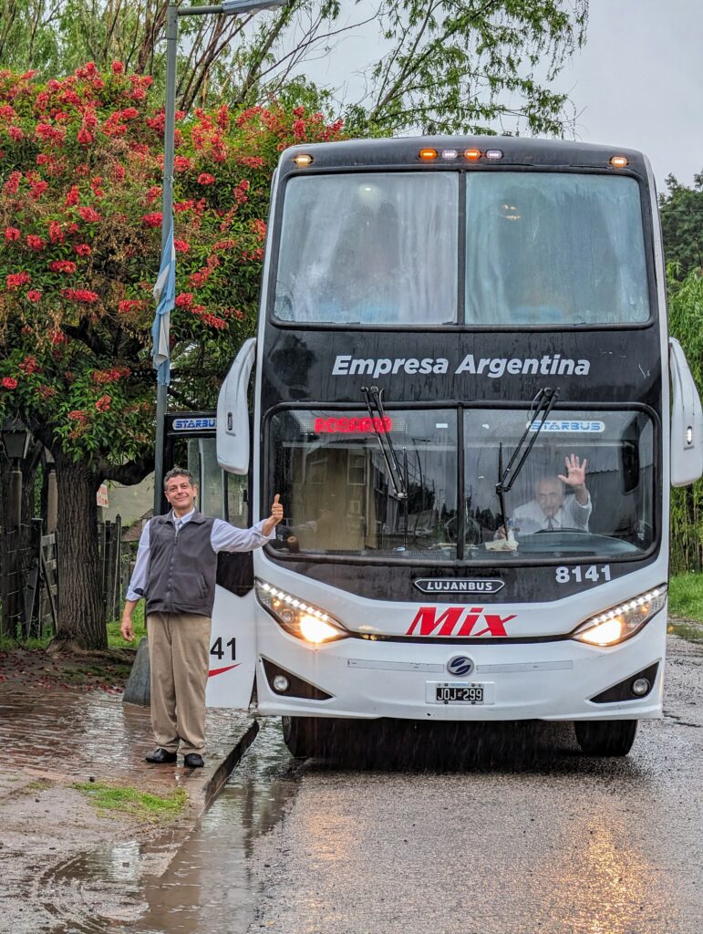 A man standing next to an 'Empresas Argentina' bus, waving as we got off the bus.