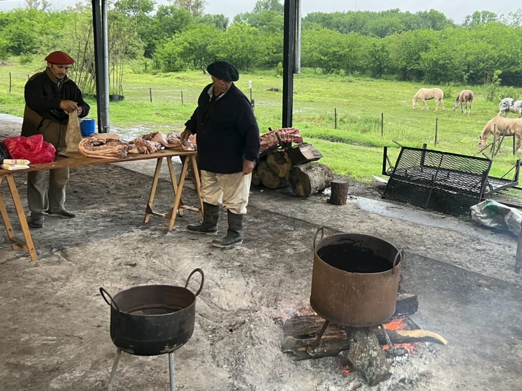 A barn setting with two people preparing to barbecue food.