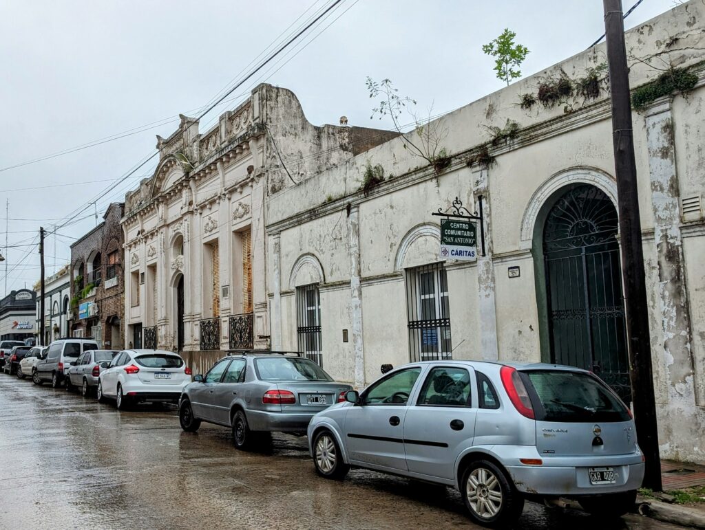 Older traditional Argentine street with cars parked in the rain