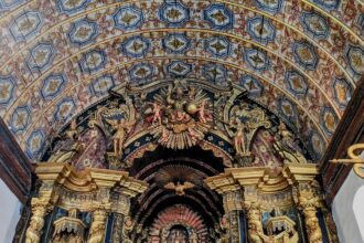 Ornate gold altar with a wood painted ceiling