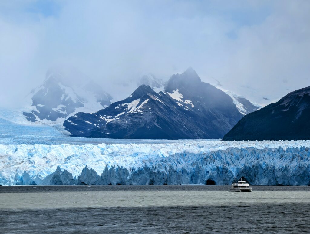 Boat in front of a glacier in front of a mountain