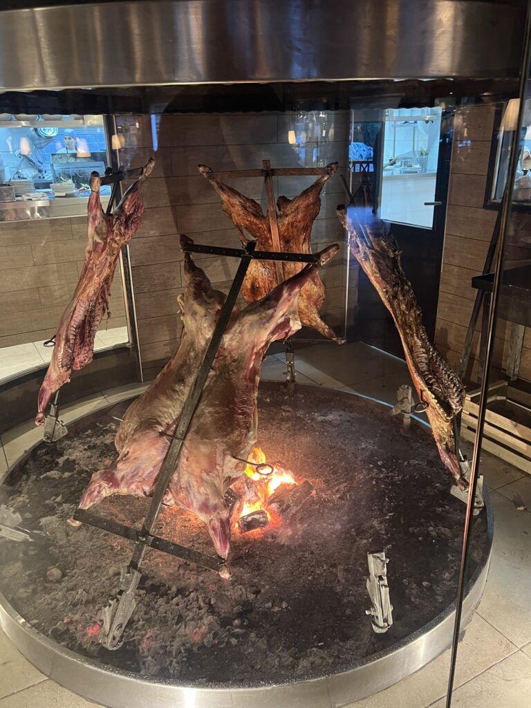 A mouthwatering sight: a massive grill with succulent meat hanging from it, ready to be savored.