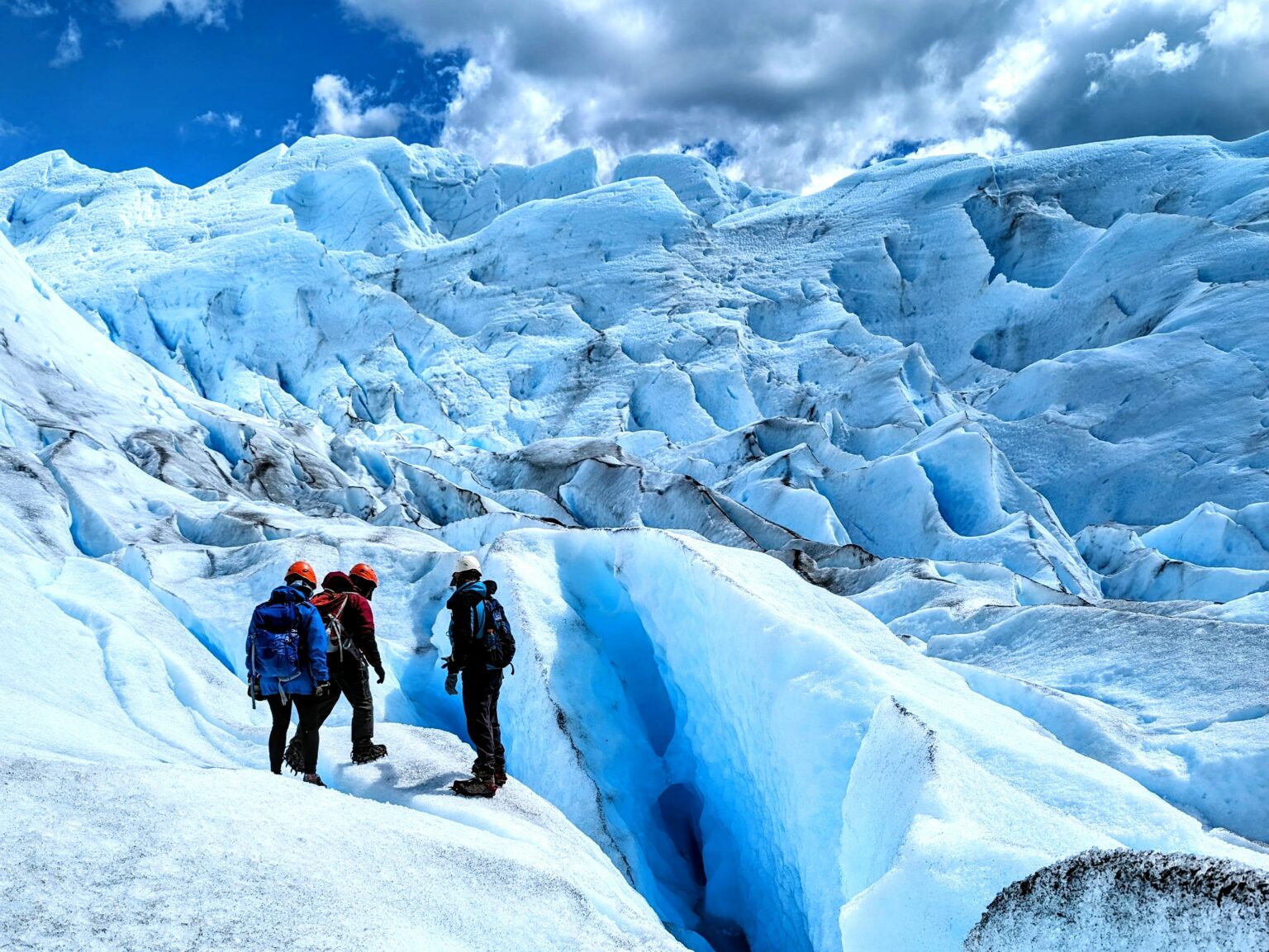 Three people captivated by the beauty of a massive glacier outside of El Calafate.
