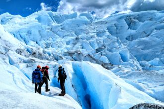 Three people captivated by the beauty of a massive glacier outside of El Calafate.