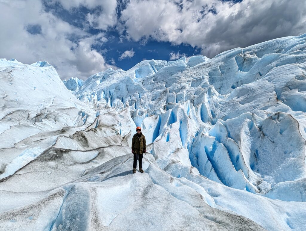 A person standing amidst a large glacier