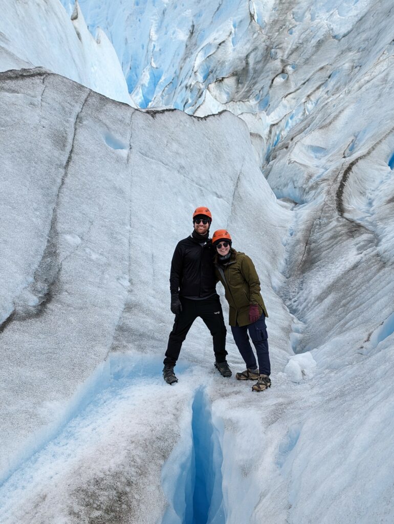 Two people standing amidst a large glacier