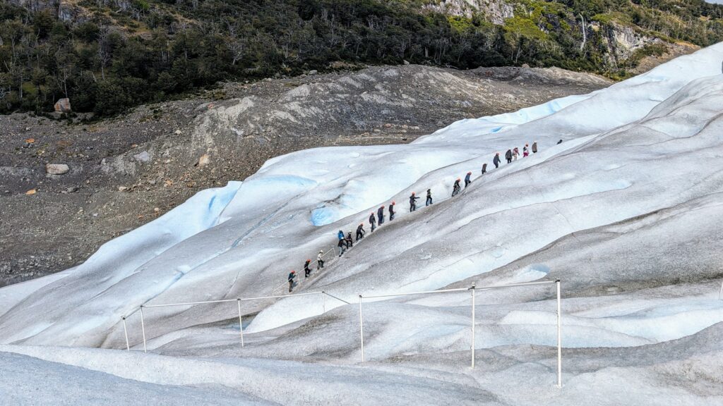 A line of people climbing up a glacier