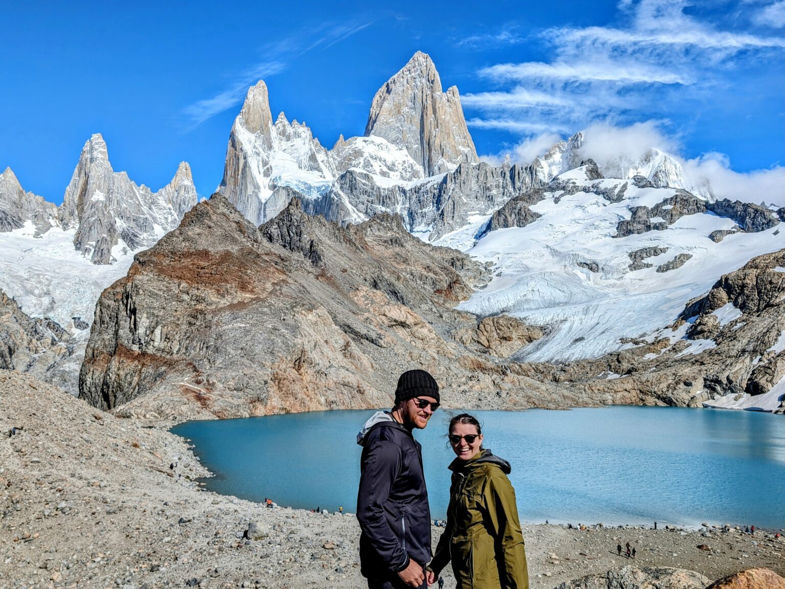 Two people enjoying the serene beauty of a mountain lake in El Chalten