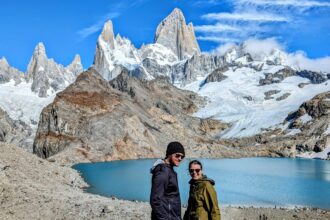 Two people enjoying the serene beauty of a mountain lake in El Chalten