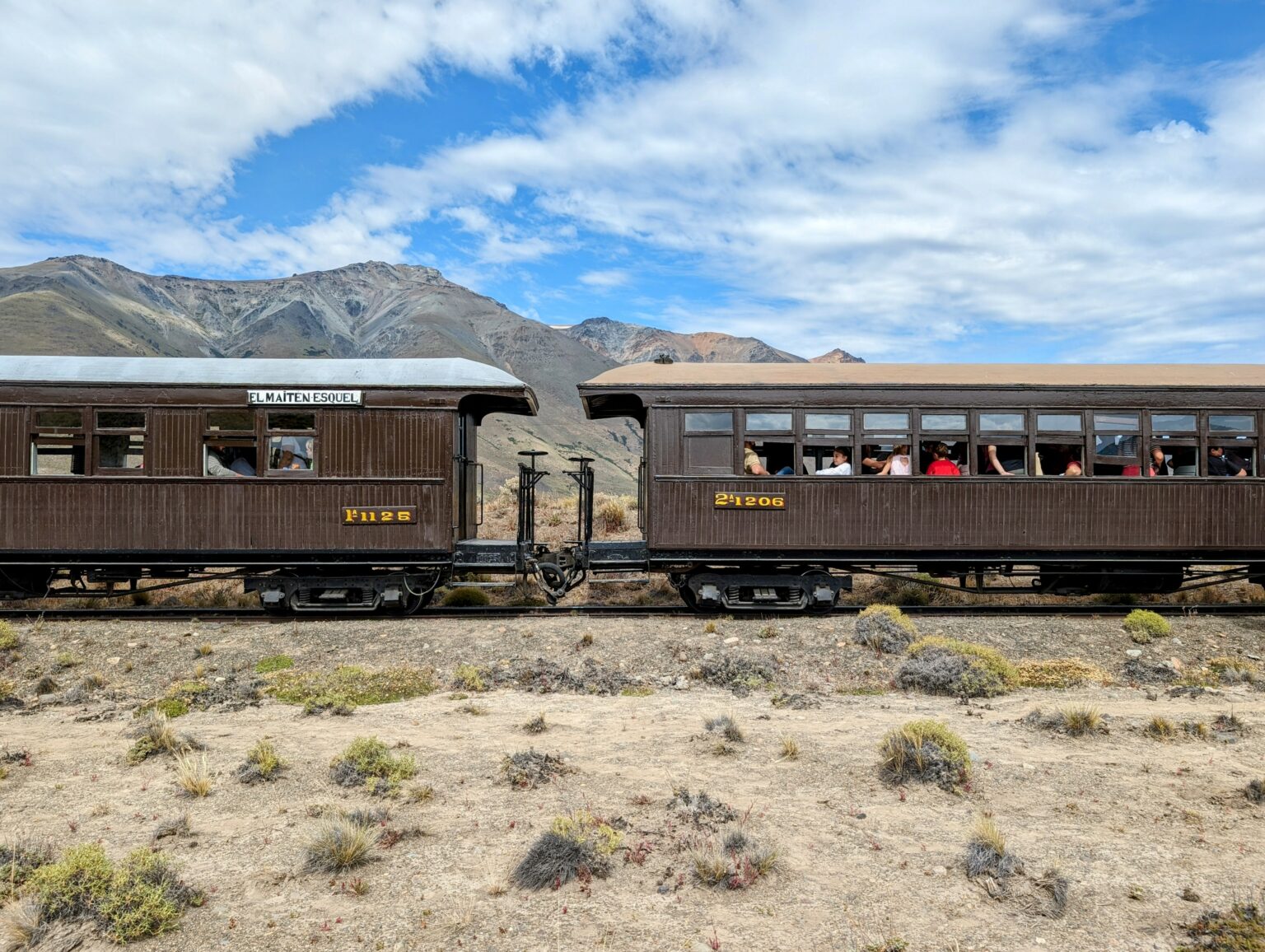 Two train cars sitting on a desert landscape