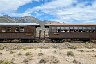 Two train cars sitting on a desert landscape