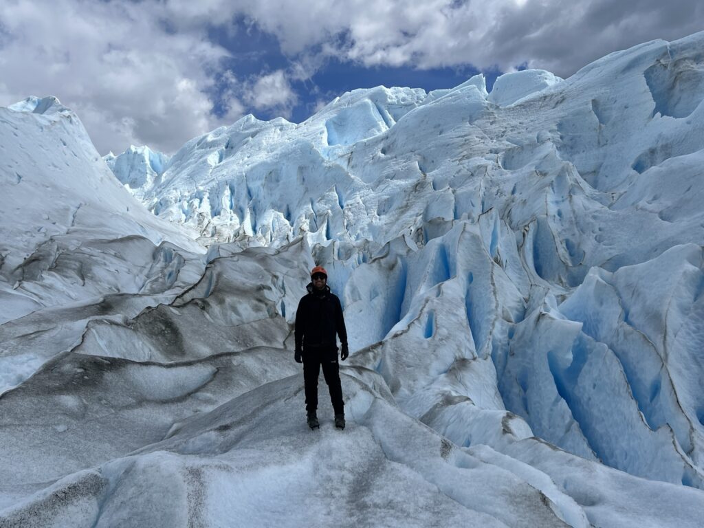 A person standing amidst a large glacier