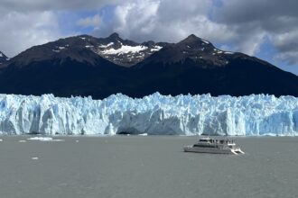 A boat sailing near a glacier in the water.