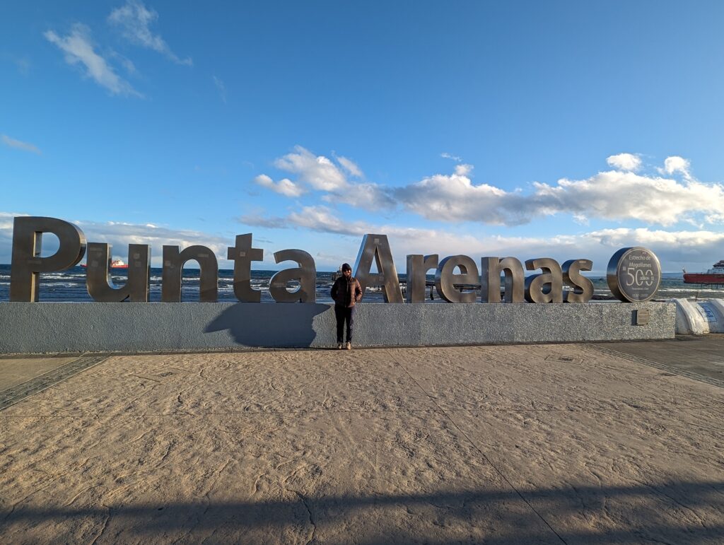 Person standing in front of a sign saying "Punta Arenas"