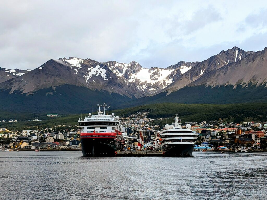 Two cruise ships docked in front of mountains