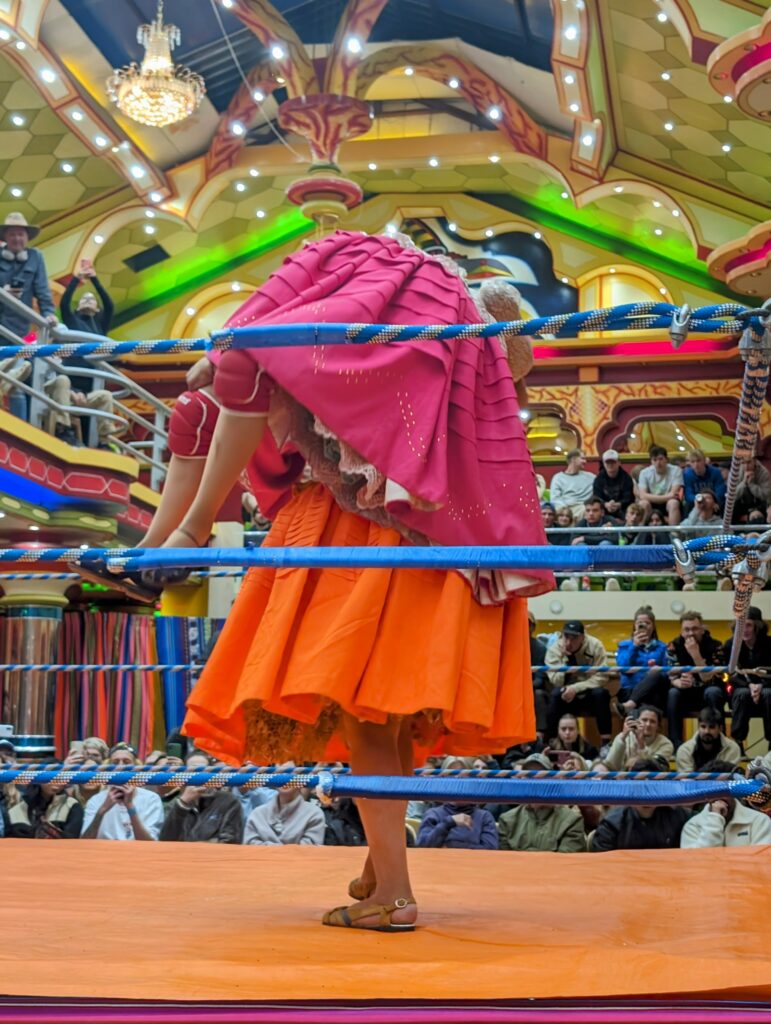 Two women in colorful skirts fighting in a rink in La Paz