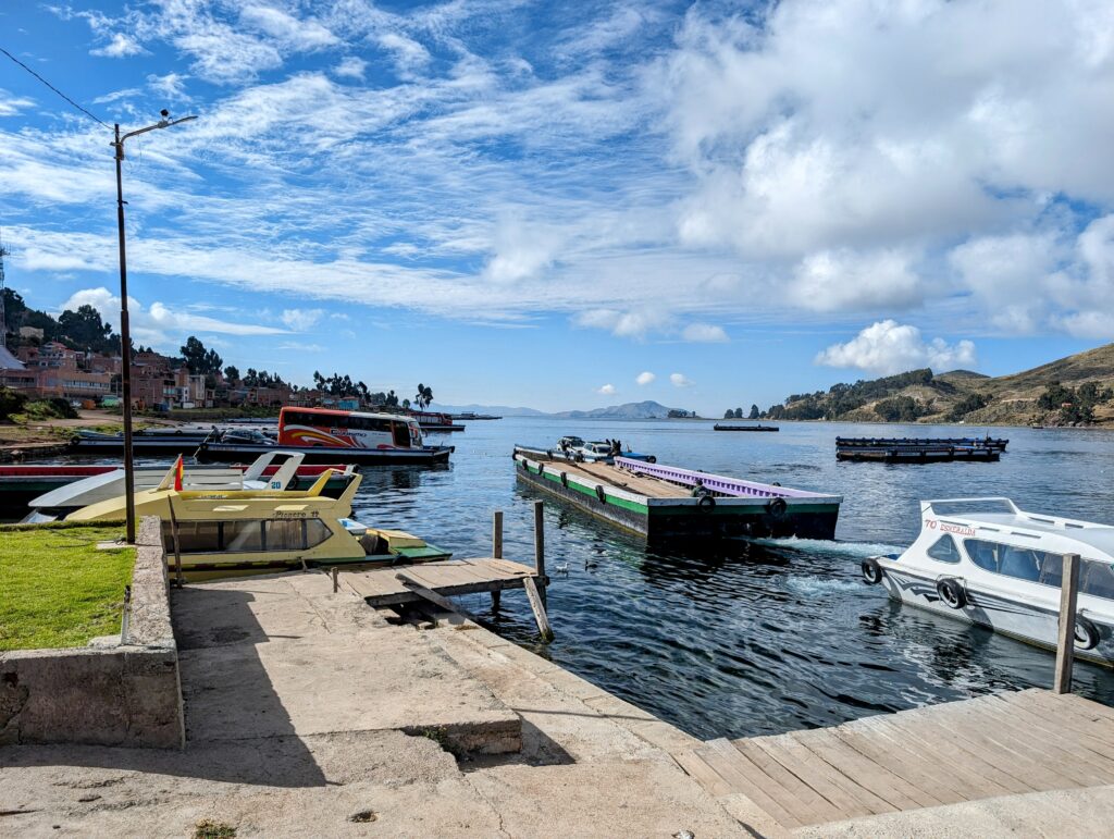 The view of a dock and a ferry carrying a bus on Lake Titicaca