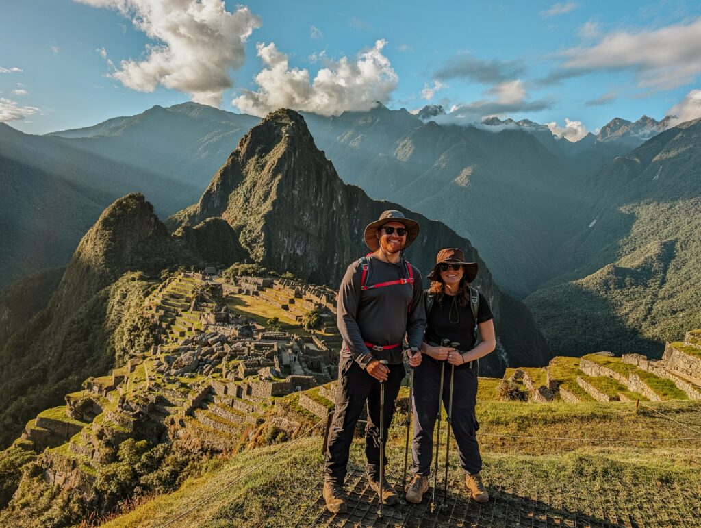 Two people standing in hiking gear in front of Machu Picchu