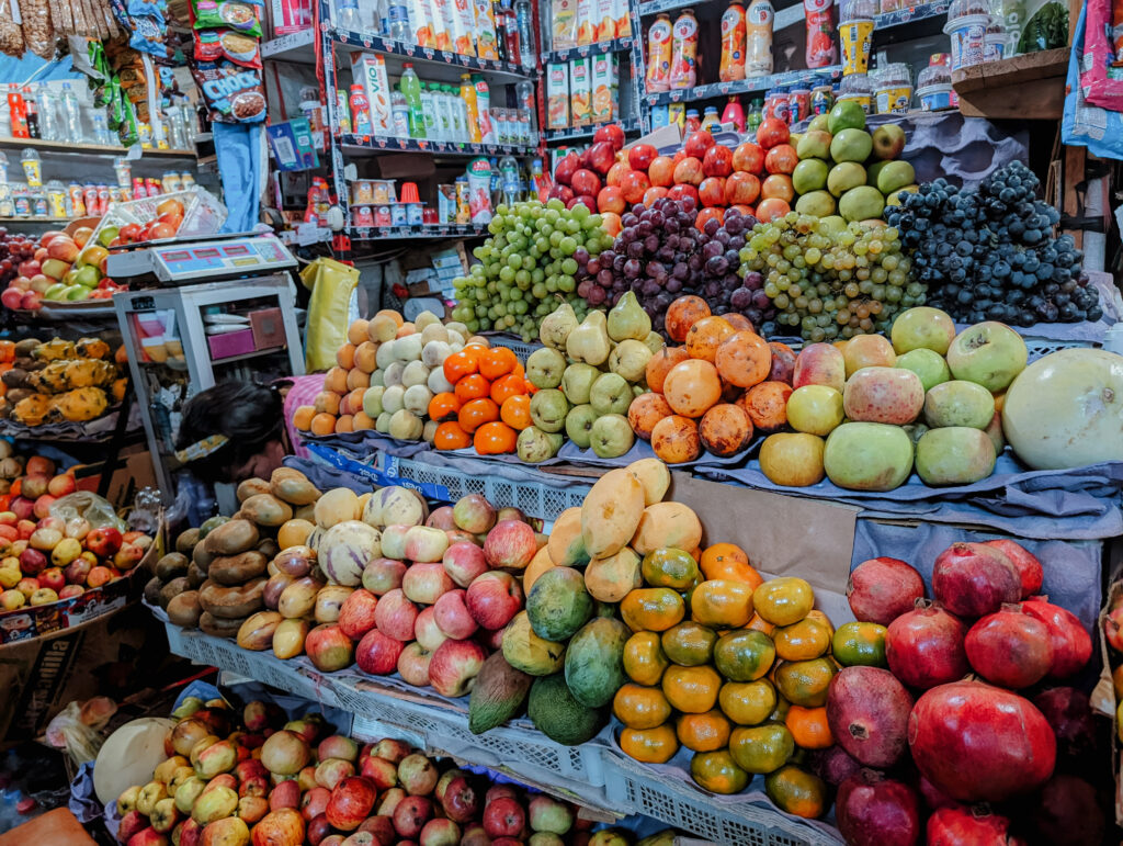 A fruit stand at a market with colorful fruit before starting the Lares Trek