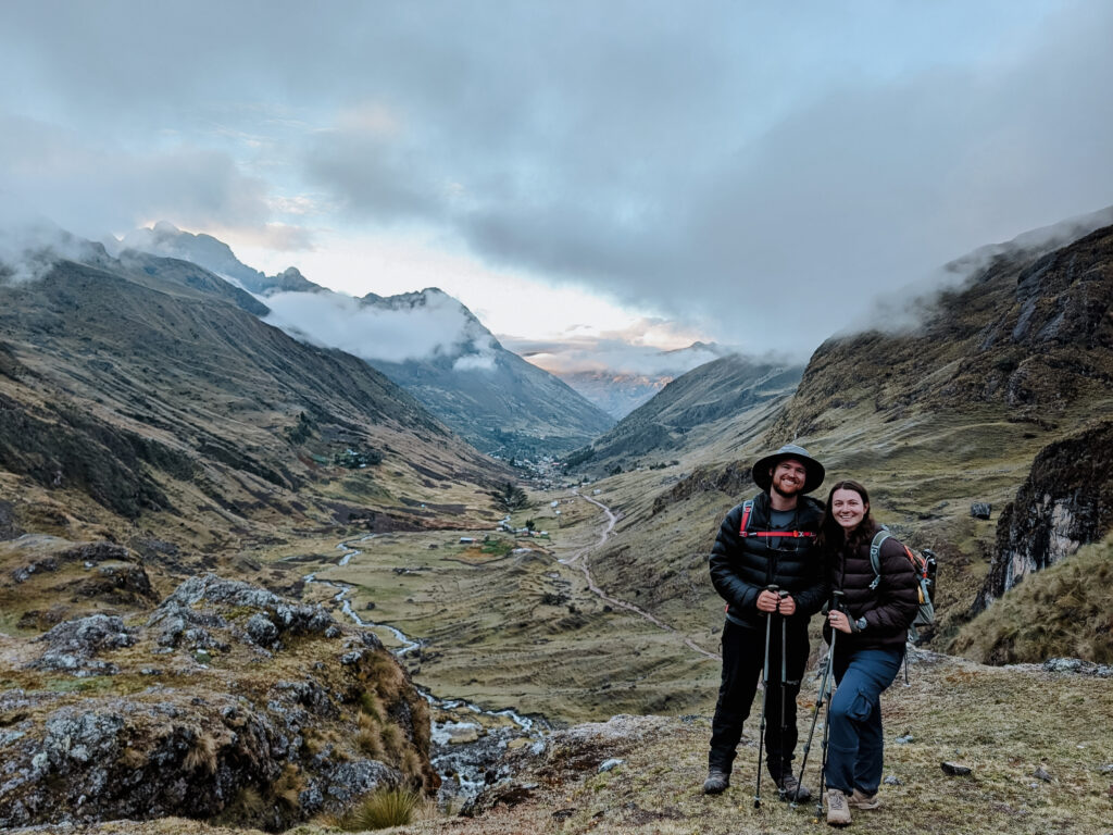 Two people standing in front of a valley while on a hike for the Lares Trek