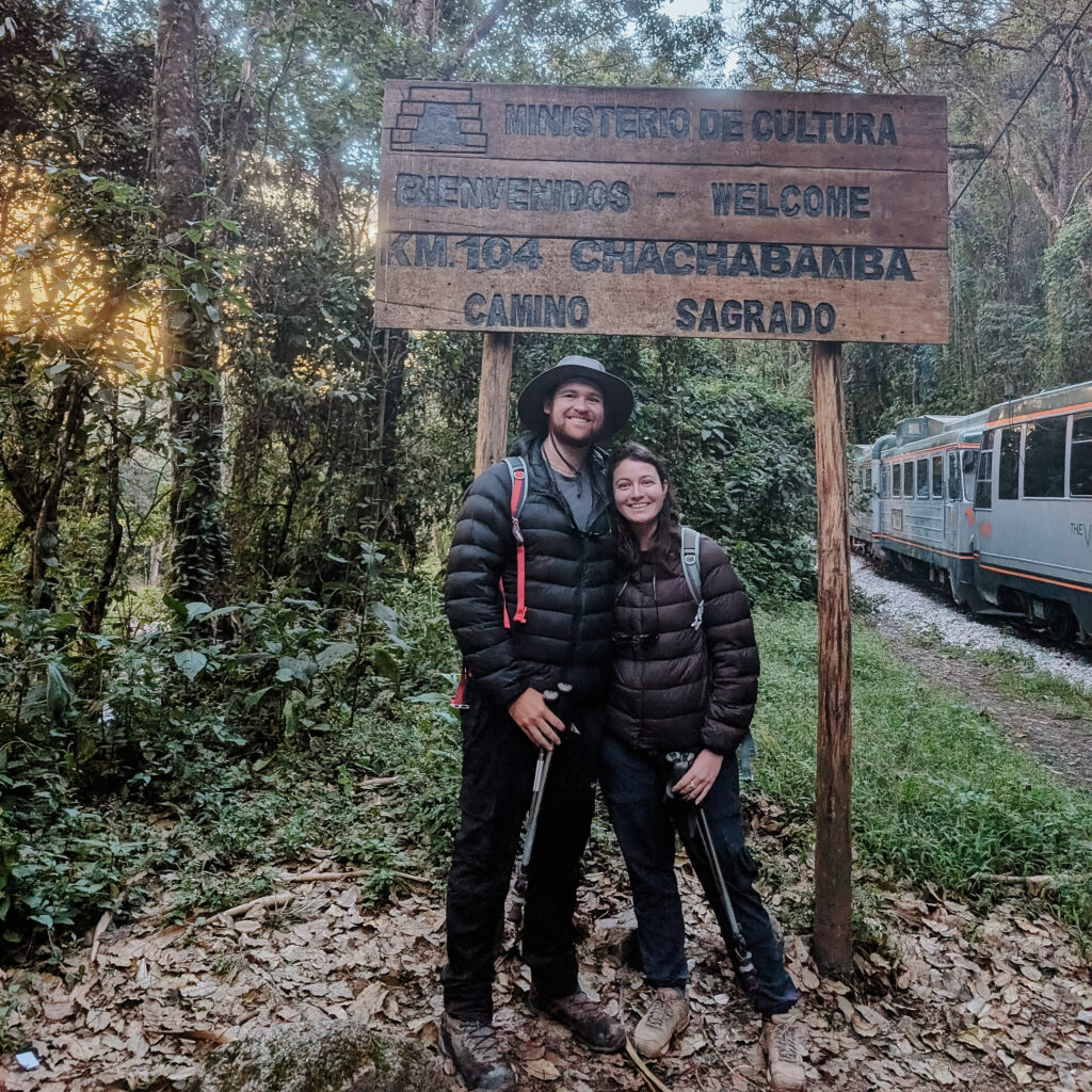 Two people standing in front of a sign at the start of the Short Inca Trail