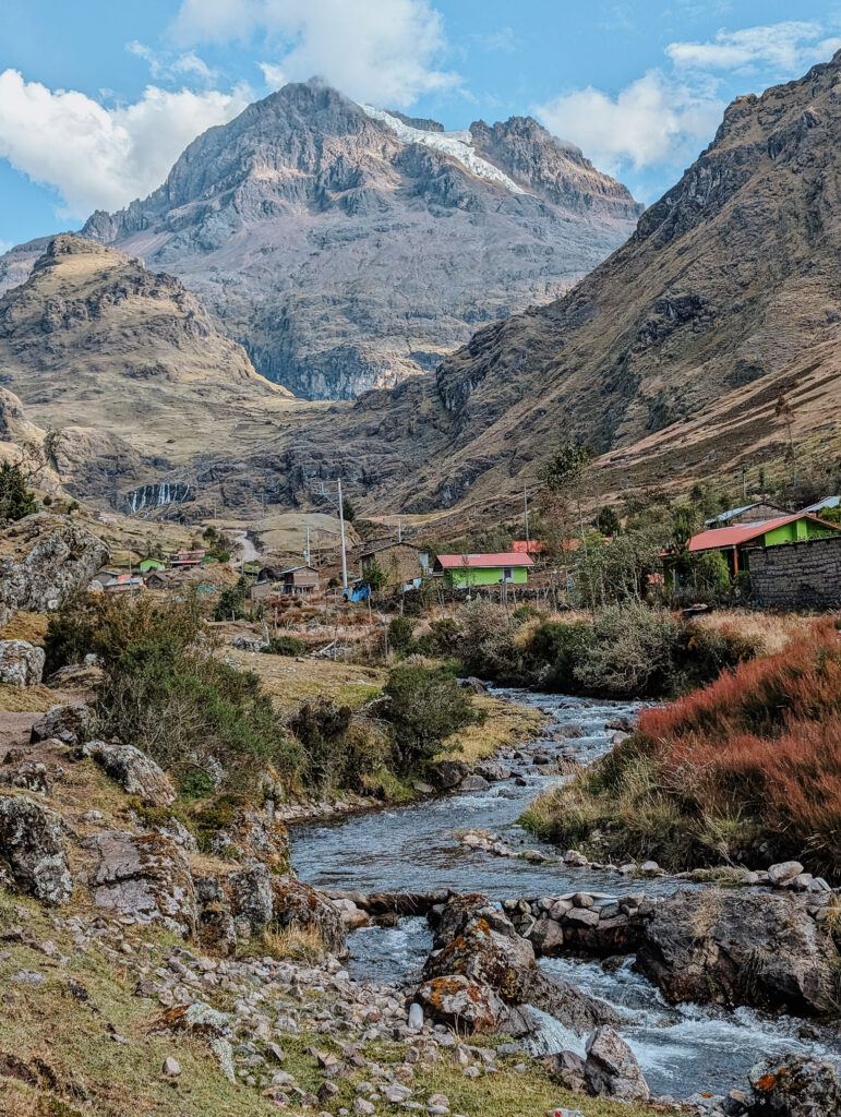 A river flowing between farmland and mountains in a valley on the Lares Trek