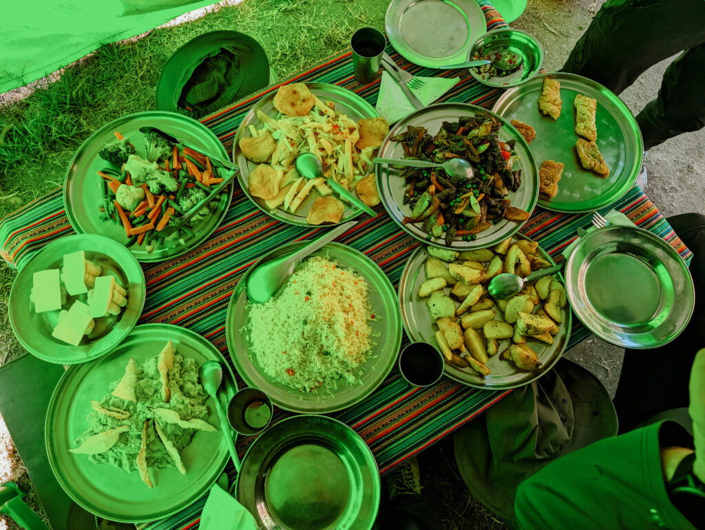 A table with many platters of food, as seen from above, on the Short Inca Trail