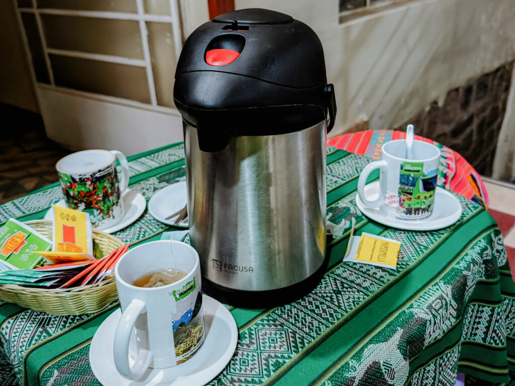 A table with a thermos of hot water and tea cups during the briefing before the Lares Trek