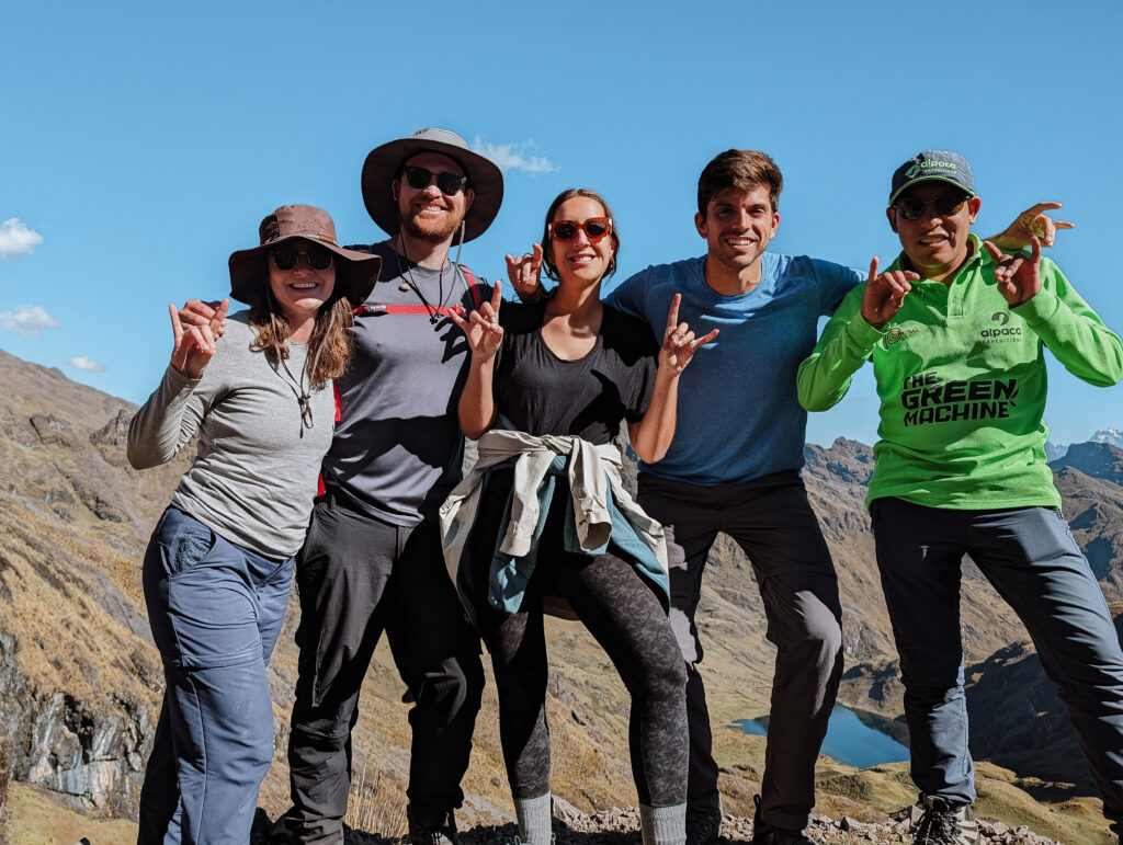 Five people posing for a photo while hiking on the Lares Trek