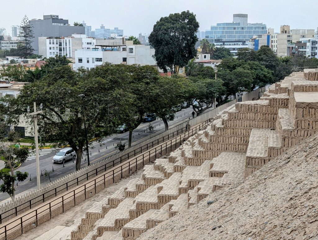 An archaeological site with tiered steps in the middle of the city of Lima