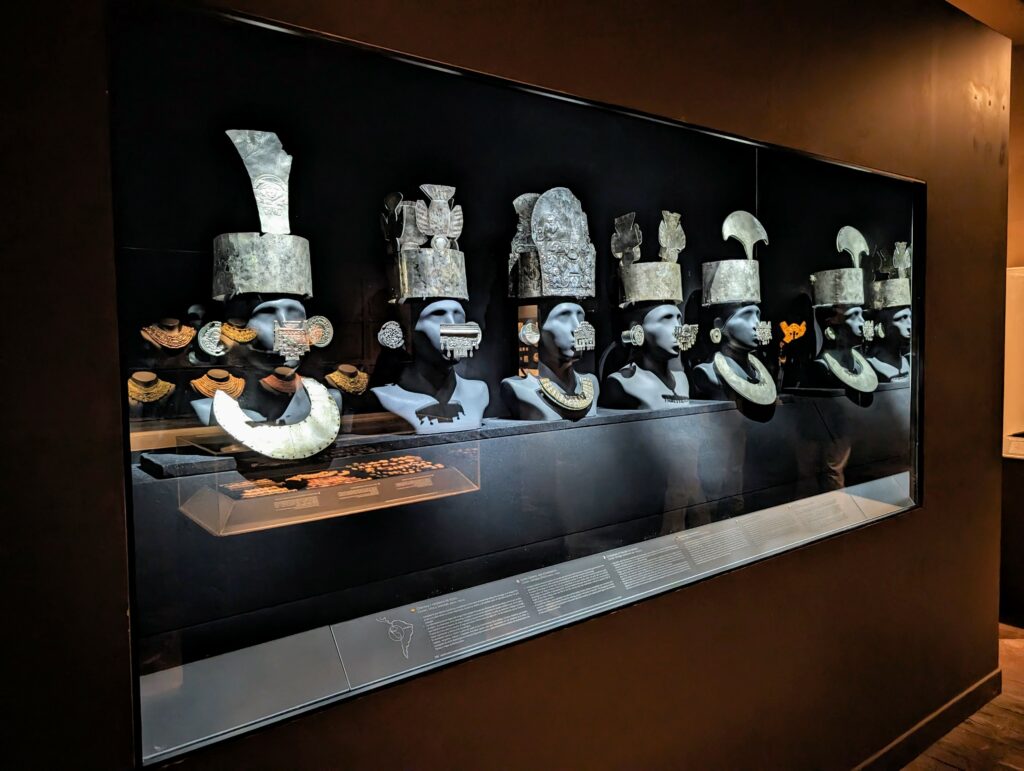 A line of 5 busts with silver jewelry and crowns at an archaeological museum in Lima