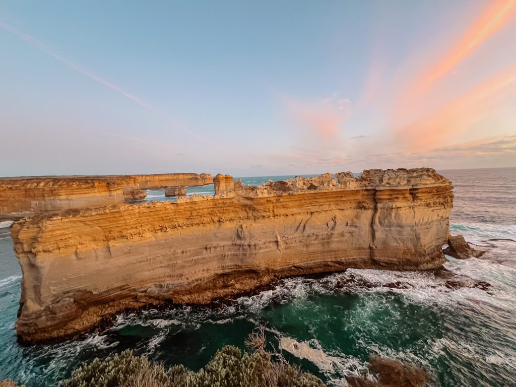 A narrow and long rock formation in the ocean as seen while driving the Great Ocean Road