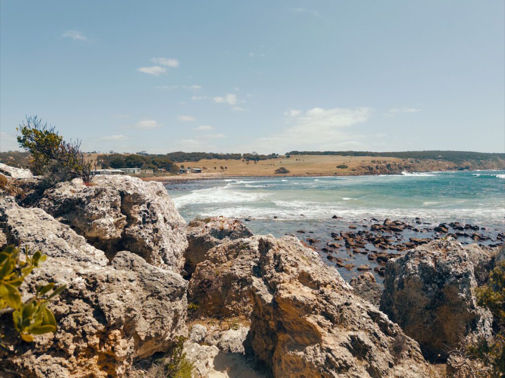 A dramatic coastline and beach of Kangaroo Island behind rocks