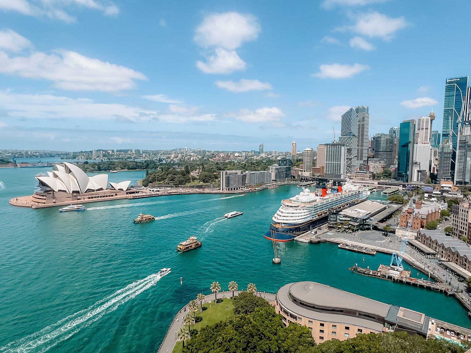 A view of the harbor of Sydney, Australia from the Sydney Harbor Bridge with boats going through the harbor