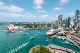 A view of the harbor of Sydney, Australia from the Sydney Harbor Bridge with boats going through the harbor