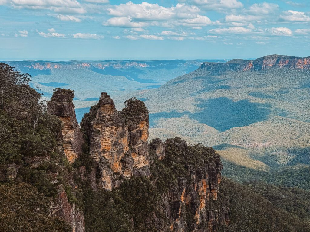 A rock structure with three peaks overlooking a green valley outside of Sydney, Australia